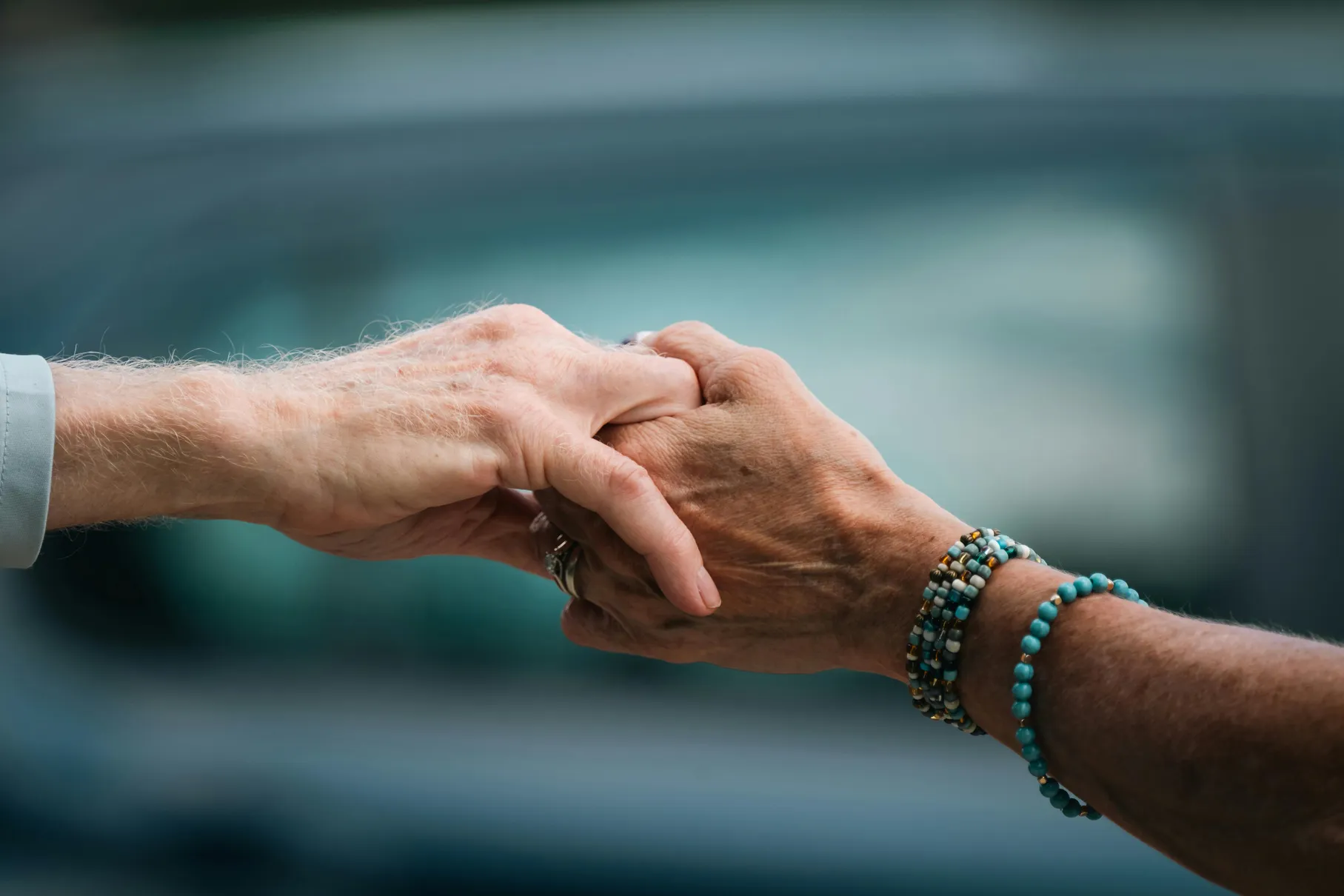 Two older hands gently holding each other