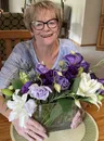LeAnn, Candace's mom, smiling with a bouquet of purple and white flowers